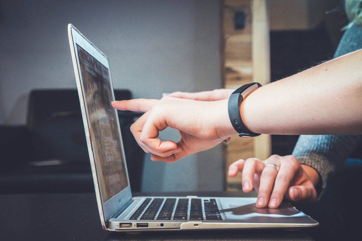 A creator pointing at her laptop, checking the app built for her audience